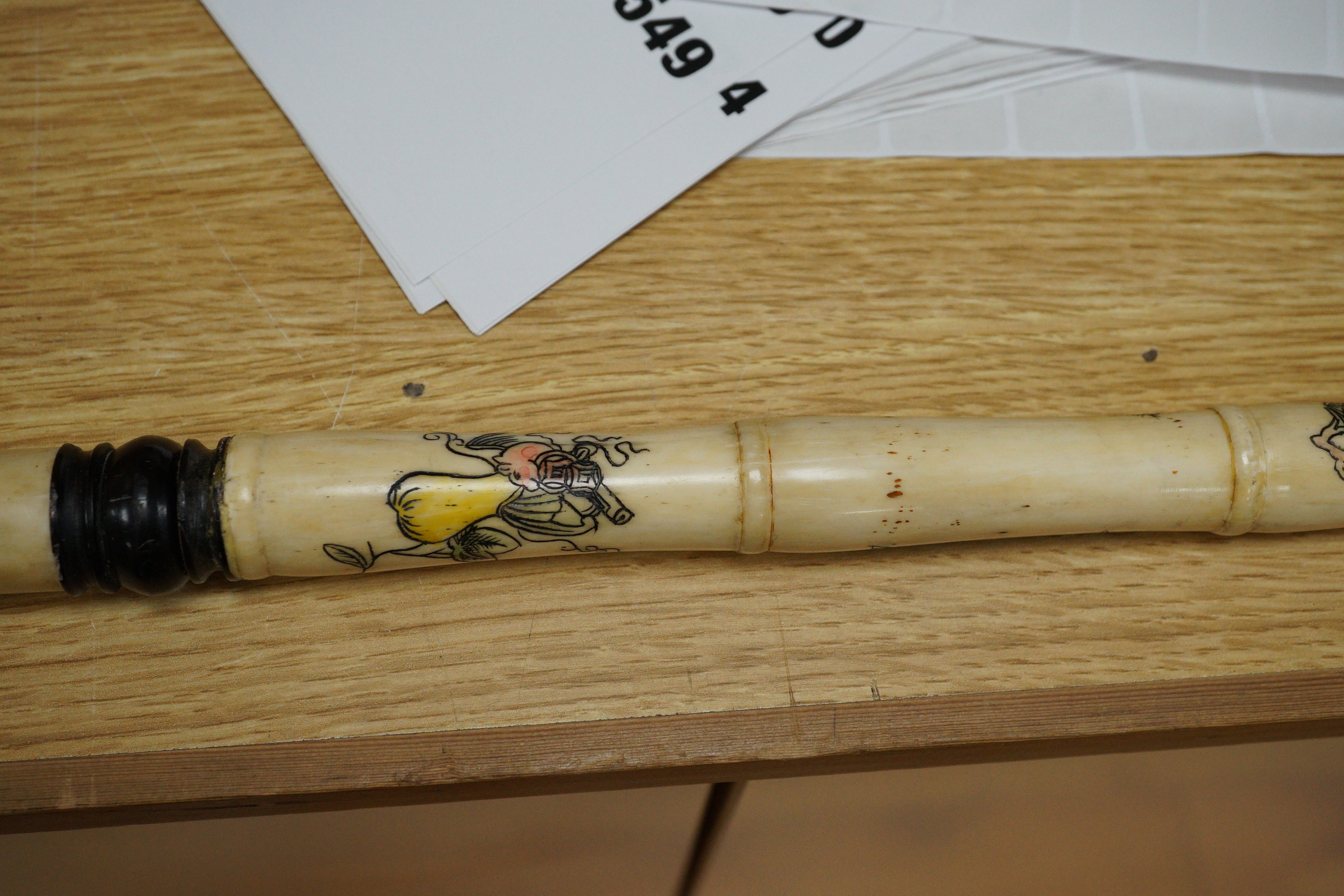 A south East Asian engraved bone and a carved ebony walking cane
